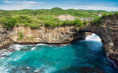 Nusa Penida 'nın kayalık kıyı şeridi. Denizin üzerinde taş kemer. Kırık plaj, Nusa Penida, Endonezya