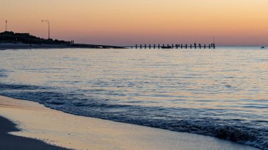 Long Point Jetty 'de gün batımında insanlar balık tutuyor ve yüzüyor, Port Kennedy - Rockingham