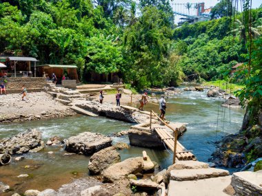 Kemenuh, Sukawati, Gianyar Regency, Bali Endonezya - 10262023 Tegenungan şelalesi sığ bir banyonun üzerindeki yemyeşil bir ormanda, kafelerin yakınında..