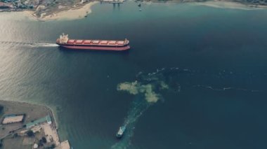 Gün batımında limana giren bir kargo gemisinin hava görüntüsü. Kargo gemisi limana demir attı..