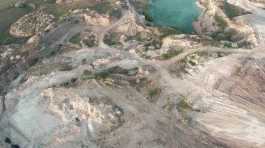Küçük bir taş ocağının hava aracı görüntüleri küçük bir göle akmış. Açılmış madenin drone görüntüsü. Açık çukurdaki suyun turkuaz arka planı.
