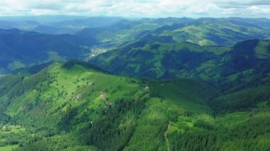 Yeşil orman dağlarındaki evlerin hava aracı görüntüleri..