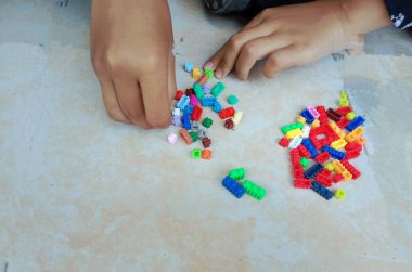 Çocuklar yerde oyuncaklarla oynuyorlar.