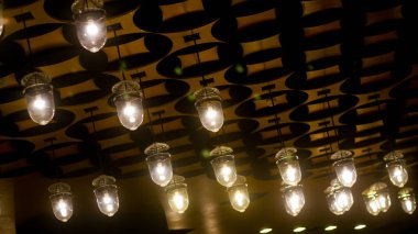 Tavan, alışveriş merkezinde modern tarzda sarı daire lambalarla süslenmiş.