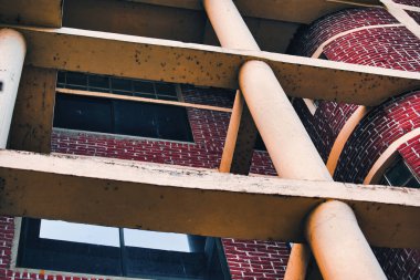 Tahta kolonları olan eski bir kırmızı tuğla bina.