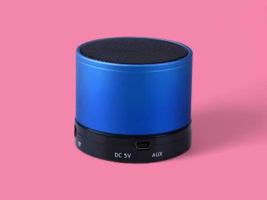 Mini mavi portatif hoparlör pembe arkaplanda.