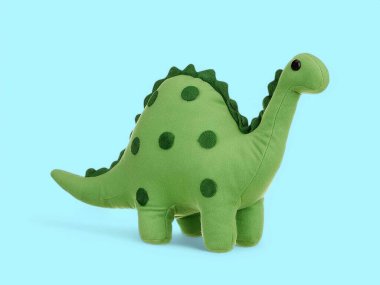 Mavi arka planda şirin bir bebek dinozor oyuncağı.