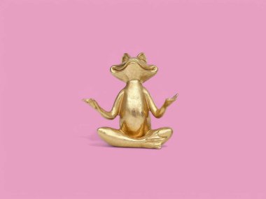 Pembe arka planda altın kurbağa heykeli meditasyonu