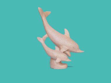 Yeşil arka planda izole edilmiş iki güzel yunus heykeli