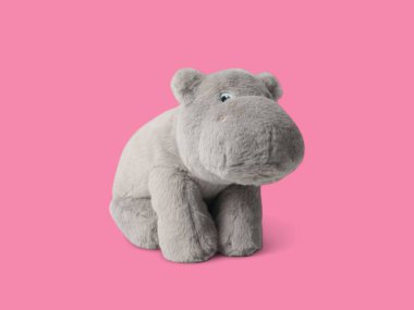 Küçük sevimli oyuncak bebek pembe arka planda izole edilmiş.