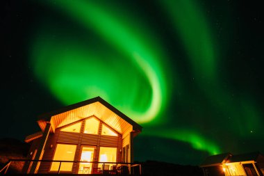 Kuzey Işıkları 'nın muhteşem manzarası İzlanda' daki bir çiftlik evinin arka planına karşı.