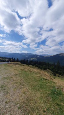 Parang Mountains seen from Transalpina road on a cloudy summer day. Green forest mountains view from mountain top. Transalpina, Valcea, Romania clipart