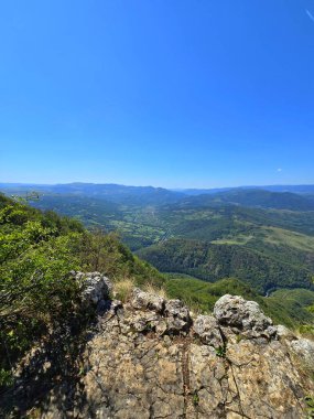 Dağların tepesindeki kayalık Bedeleu Dağı 'ndan ve yakınlardaki Aries Vadisi' nden görüntü geliyor. Güneşli bir yaz gününde yeşil ormanın üzerinde yüksek uçurum. Salciua, Alba, Romanya