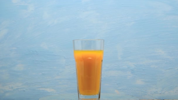 Rotation Orange Juice Glass Cocktail Orange Juice Blue Background — Vídeos de Stock