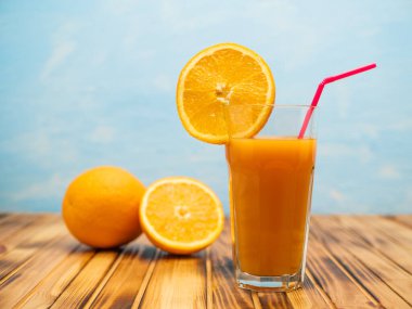 Orange juice in a glass with a slice of orange and an straw.