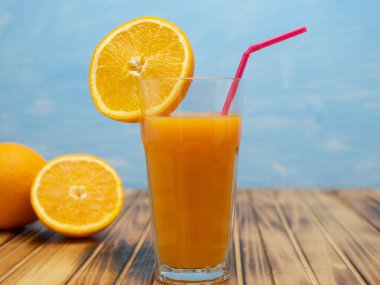 Fresh juice, mix fruits, orange drink on a blue background. Glass with orange cocktail.