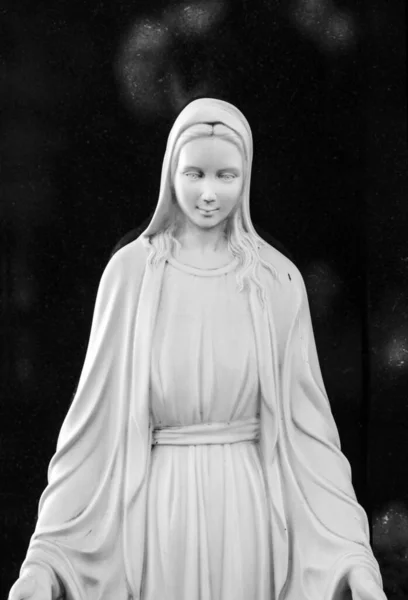 White marble statue of blessed Mary mother of god, black and white image