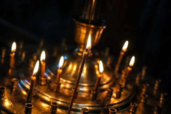 Votive candles burning on special candlestick in orthodox church