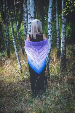 Kırk yaşında bir kadın huş ağacında kendi elleriyle örgü örüyor.