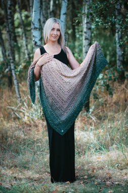 Kırk yaşında bir kadın huş ağacında kendi elleriyle örgü örüyor.