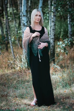 Kırk yaşında bir kadın huş ağacında kendi elleriyle örgü örüyor.