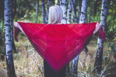 Kırk yaşında bir kadın huş ağacında kendi elleriyle örgü örüyor.