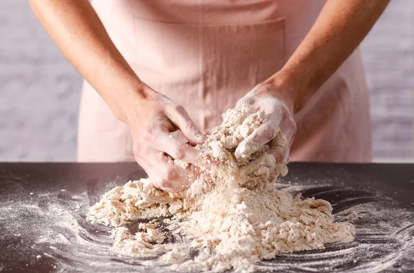 女性の手は台所のテーブルの上に生地をこねる クローズアップ 調理工程 — ストック写真