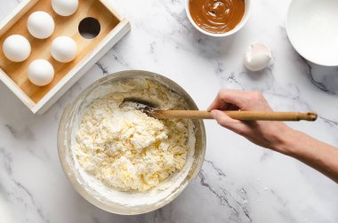 Kurabiye ve mısır nişastası yapmak için hamuru hazırlıyorum. Yumurta, tereyağı, mısır nişastası, kabartma tozu ve beyaz mermer arka planda dulce de leche..