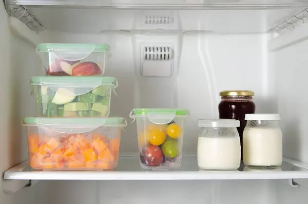 Buzdolabında yiyecek saklama kavramı. Meyveler, plastik kaplarda sebzeler yoğurt ve kavanozlarda reçel..