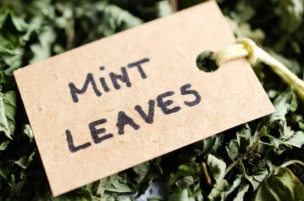 Kurumuş nane yaprakları ve geri dönüşümlü kağıtta İngilizce yazılmış bir etiket.. 