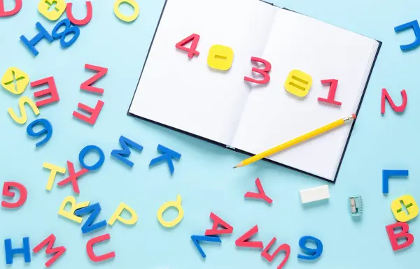 Defterde sayılar ve sembollerle açık mavi arkaplana dağılmış renkli alfabe harfleriyle matematik denklemi. Okul konseptine dönelim..