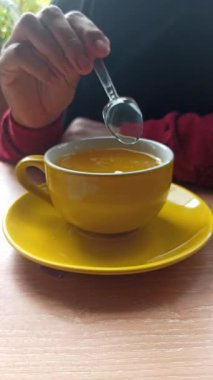 Sıcak portakal suyu parlak sarı bir fincanda servis edilir, buharlı ve güzel kokulu, sıcak ve sıcak tropikal titreşimler serinletici bir narenciye anı için mükemmeldir..