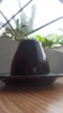 Parlak siyah bir fincan, boş veya içecekle dolu, minimalist tasarım ve modern zarafet, kahve ve çay anları için mükemmel..