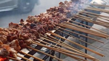 Madura satay ızgara dumanlı aroma ve parlayan kömür ile geleneksel Endonezya sokak yemeklerini ihtiras ve lezzetle hazırlıyor..