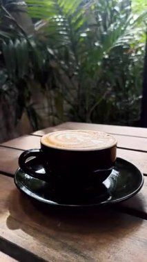 Sıcak bir kapuçino kremalı köpüklü, rahat bir kafede oturur, aroması ve latte sanatı sizi rahatlamaya ve mükemmel kahve anının tadını çıkarmaya davet eder.