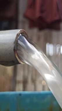 Basit bir musluk günlük su ihtiyacını karşılıyor, açık havada kuruluyor, temel faydaları ve temiz suya pratik erişimi gösteriyor.