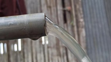 Basit bir musluk günlük su ihtiyacını karşılıyor, açık havada kuruluyor, temel faydaları ve temiz suya pratik erişimi gösteriyor.