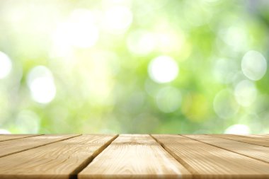 Doğanın tarzından soyut yeşil bokeh 'in bulanık görüntüsüne sahip boş ahşap tablo.