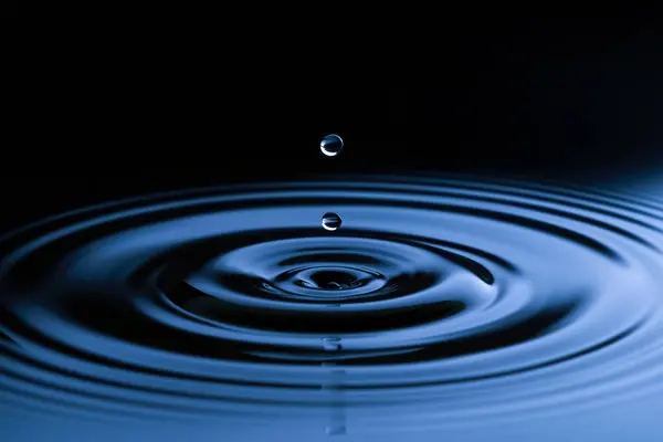 水滴击中水的清洁表面的特写 免版税图库图片