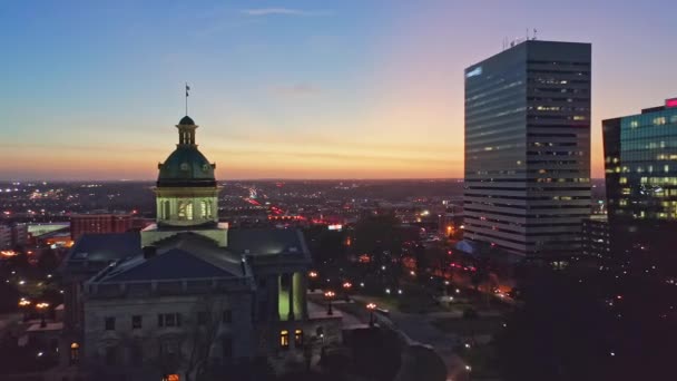 サウスカロライナ州庁舎とコロンビアのスカイラインを夜間に空中で撮影した サウスカロライナ州議会議事堂はサウスカロライナ州政府が入居する建物である — ストック動画