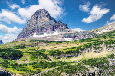 Clements Mountain and Going-To-The Sun road winding up to Logan Pass Visitor Center in Glacier National Park, Montana. Clements Mountain is located in the Lewis Range. clipart