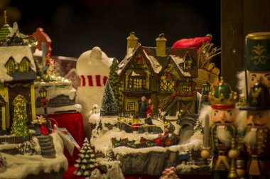 Vitrin, ahşap ve seramik Noel hediyeleriyle bir dükkanda Advent Bazaar Stalls. Yılbaşı tatilinde kış sokağı gece pazarında ağaç için yapılan şenlikli süslemeleri kapatın. Aydınlatılmış açık büfe