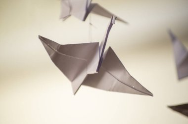 Japanese folded Origami cranes hanging on with strings. Hundreds handmade paper birds isolated with copy space. 1000 thousand crane tsuru sculpture topic. Symbol of peace, faith, health, wishes, hope