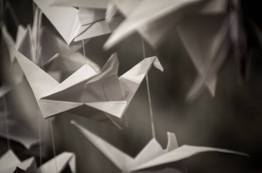 Japanese folded Origami cranes hanging on with strings. Hundreds handmade paper birds isolated with copy space. 1000 thousand crane tsuru sculpture topic. Symbol of peace, faith, health, wishes, hope