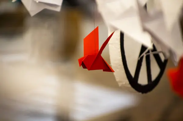 Japanese folded Origami cranes hanging on with strings. Hundreds handmade paper birds isolated with copy space. 1000 thousand crane tsuru sculpture topic. Symbol of peace, faith, health, wishes, hope