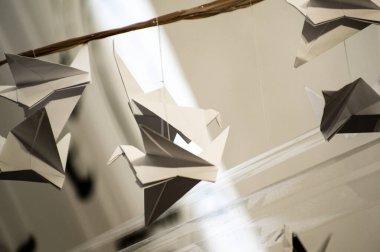 Japanese folded Origami cranes hanging on with strings. Hundreds handmade paper birds isolated with copy space. 1000 thousand crane tsuru sculpture topic. Symbol of peace, faith, health, wishes, hope