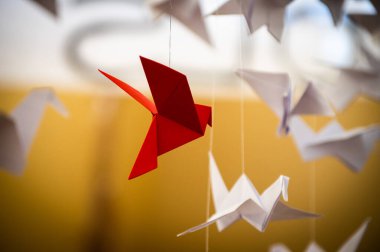 Japanese folded Origami cranes hanging on with strings. Hundreds handmade paper birds isolated with copy space. 1000 thousand crane tsuru sculpture topic. Symbol of peace, faith, health, wishes, hope