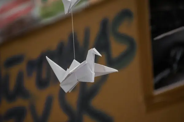 Japanese folded Origami cranes hanging on with strings. Hundreds handmade paper birds isolated with copy space. 1000 thousand crane tsuru sculpture topic. Symbol of peace, faith, health, wishes, hope