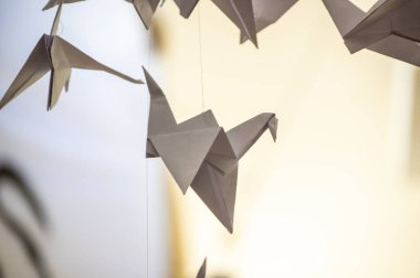Japanese folded Origami cranes hanging on with strings. Hundreds handmade paper birds isolated with copy space. 1000 thousand crane tsuru sculpture topic. Symbol of peace, faith, health, wishes, hope