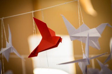 Japanese folded Origami cranes hanging on with strings. Hundreds handmade paper birds isolated with copy space. 1000 thousand crane tsuru sculpture topic. Symbol of peace, faith, health, wishes, hope